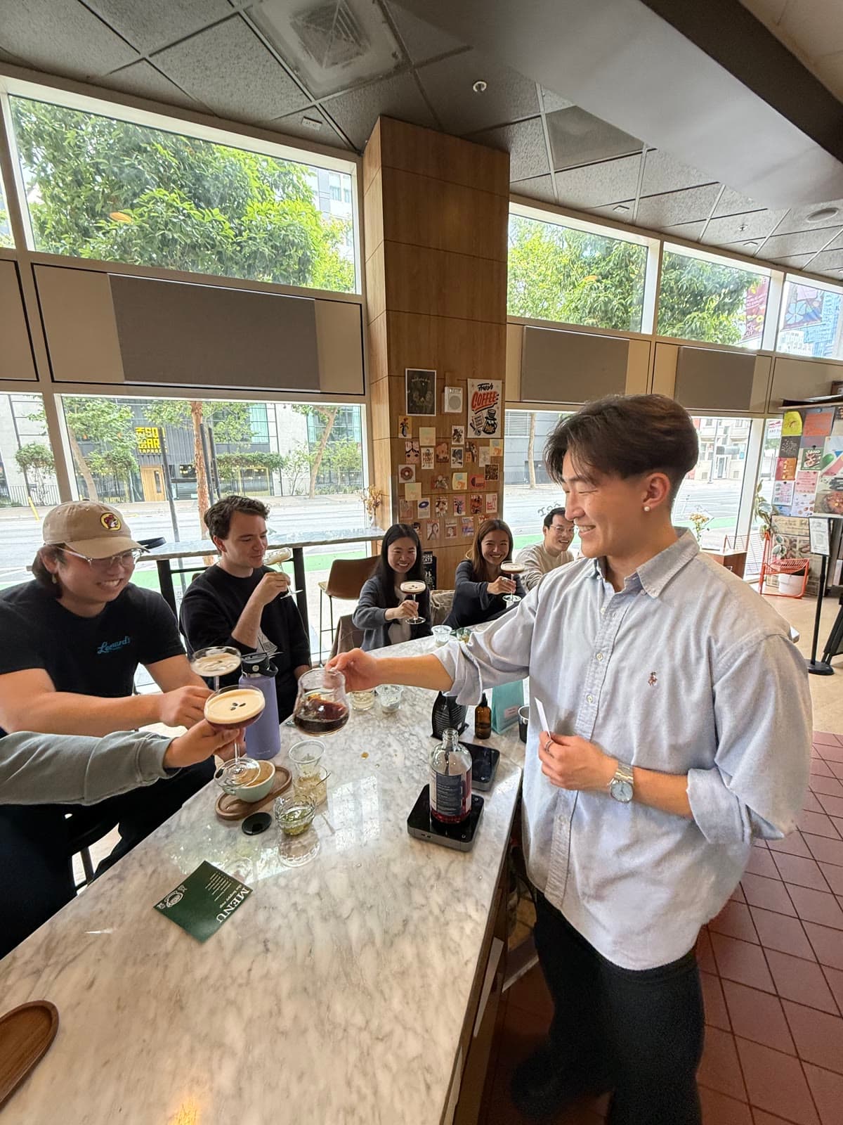John serving coffee to a group at a coffee pop-up